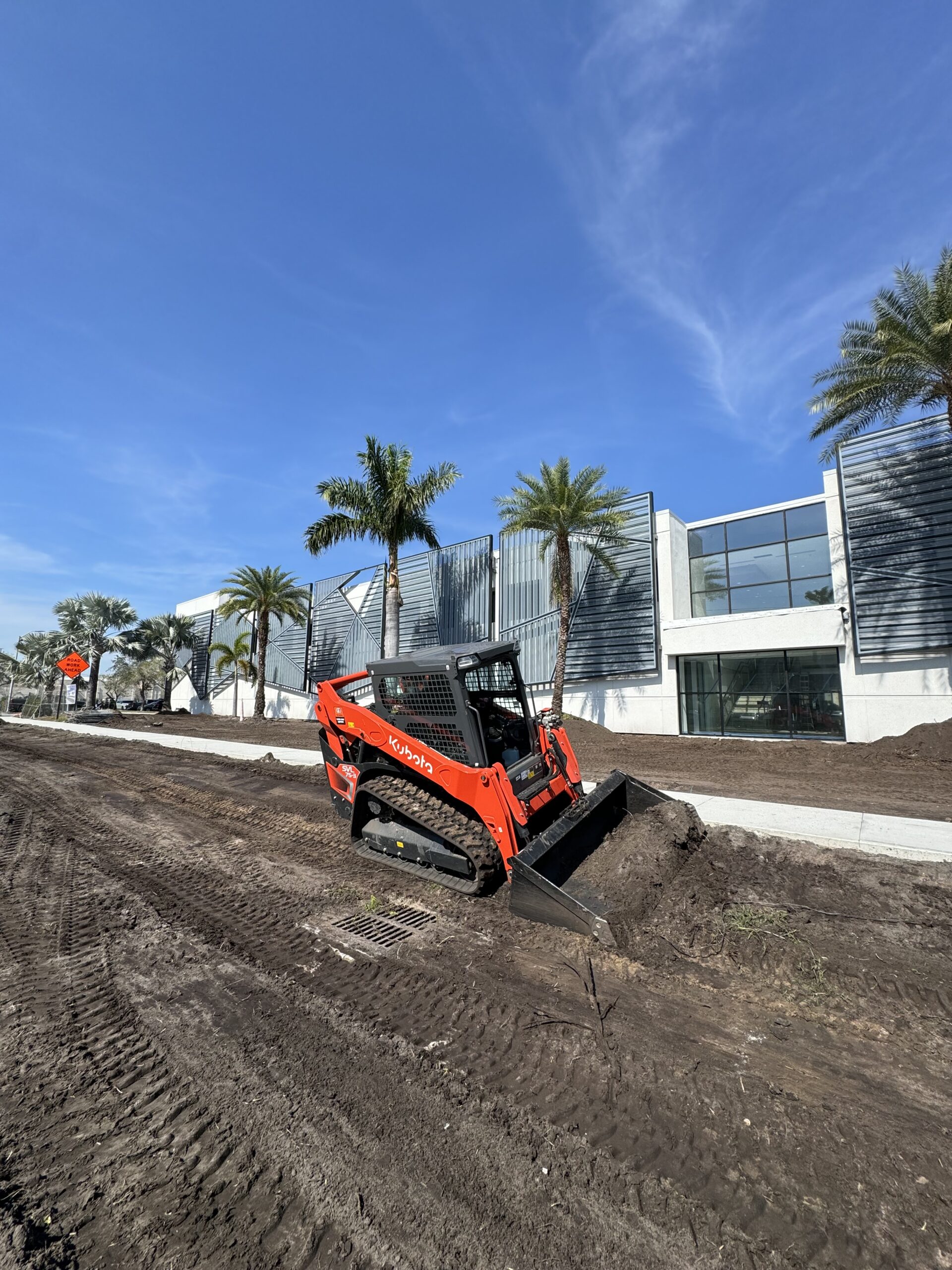 Final grading of commercial building site for drainage and site preparation in Orlando Florida