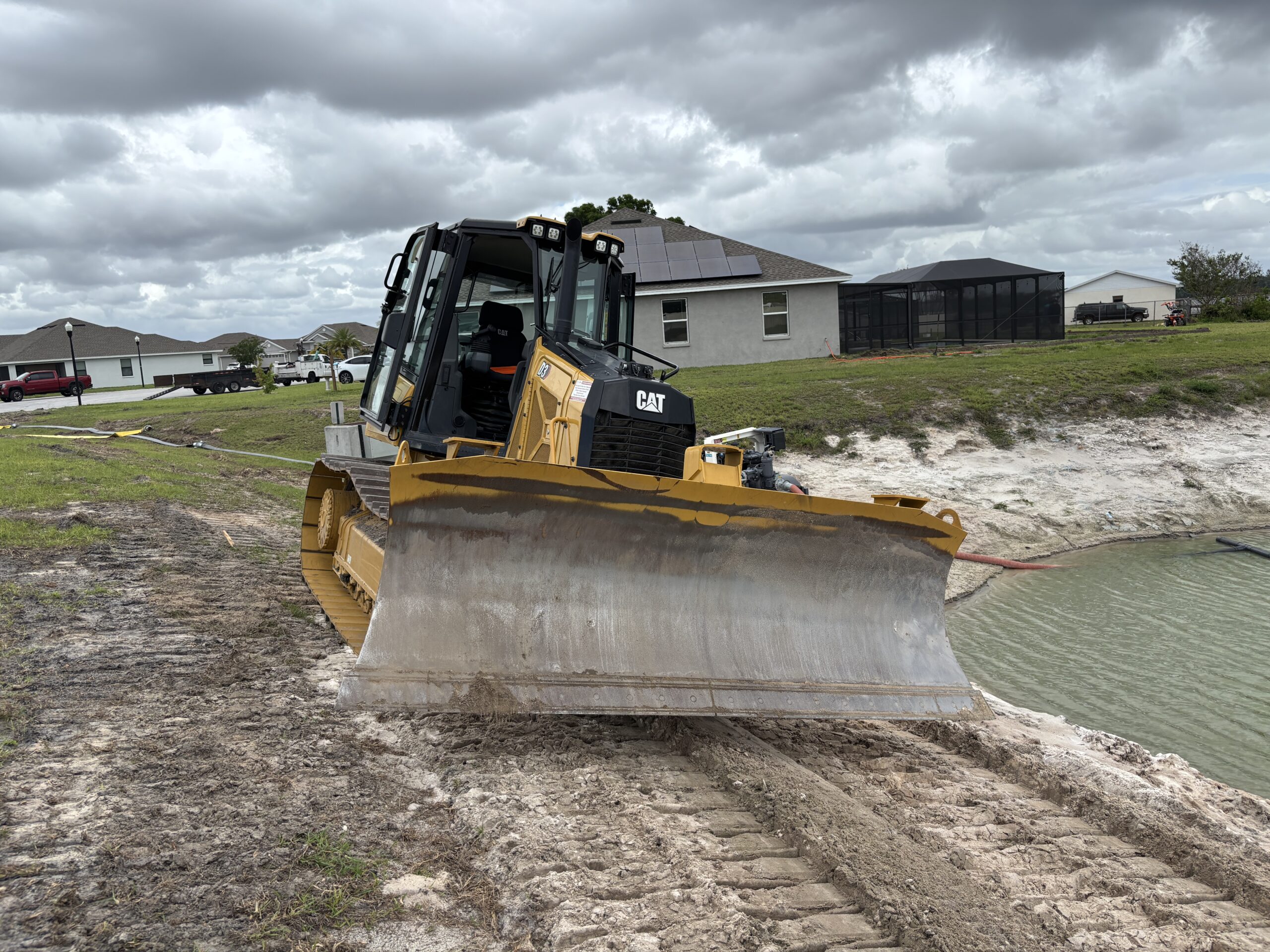 Cat D3 dozer grading retention pond to a 4 to 1 slope for proper drainage and erosion control