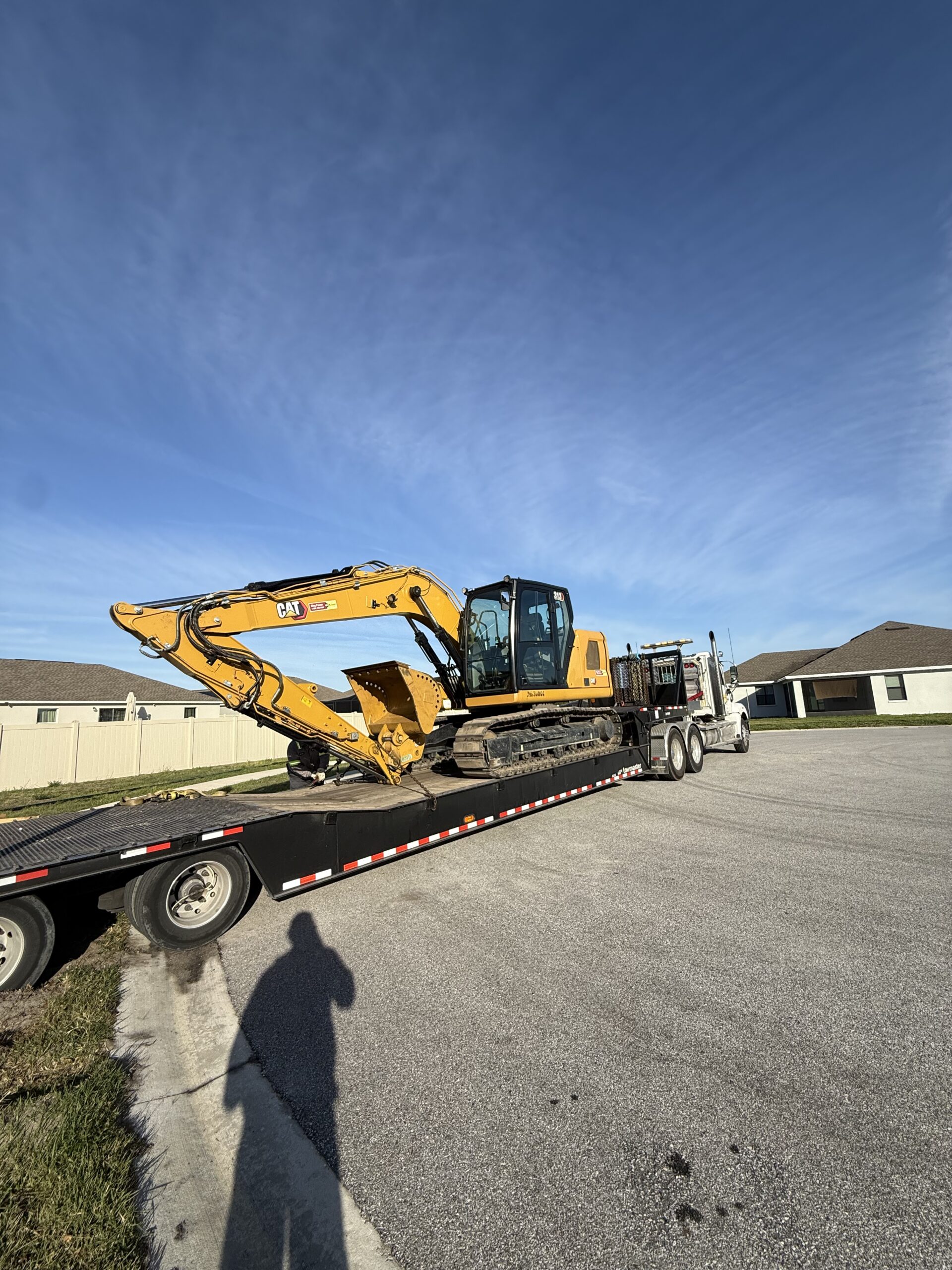 Excavator loading demolition debris into dumpsters during site cleanup in Central Florida